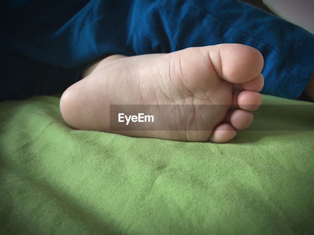 Low section of boy lying on bed