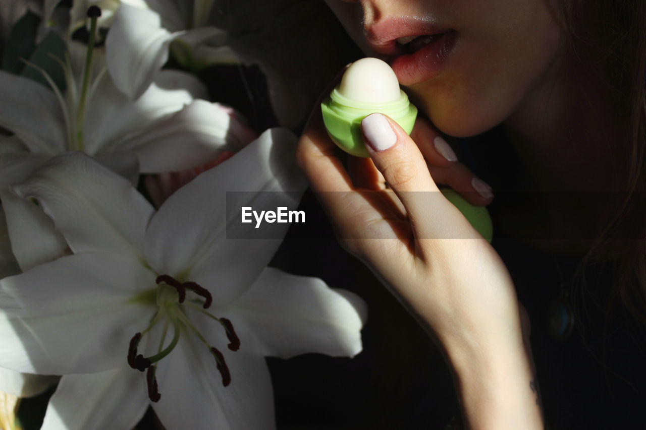 Close-up of woman applying lip balm