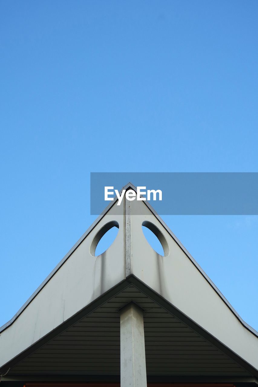 Low angle view of building roof against clear sky