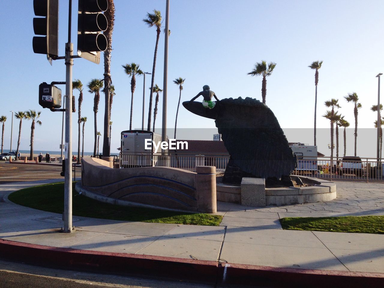 STATUE BY PALM TREE AGAINST SKY