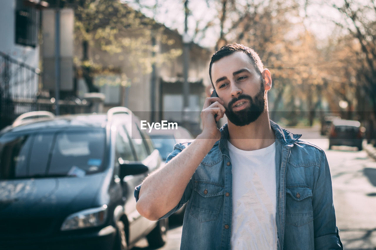 Man talking on mobile phone in city