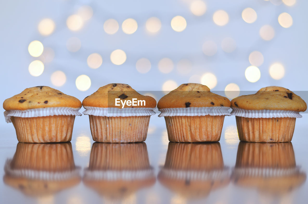 Christmas sweet cupcakes, candles in form of numbers 2023. white background, bokeh. new year 