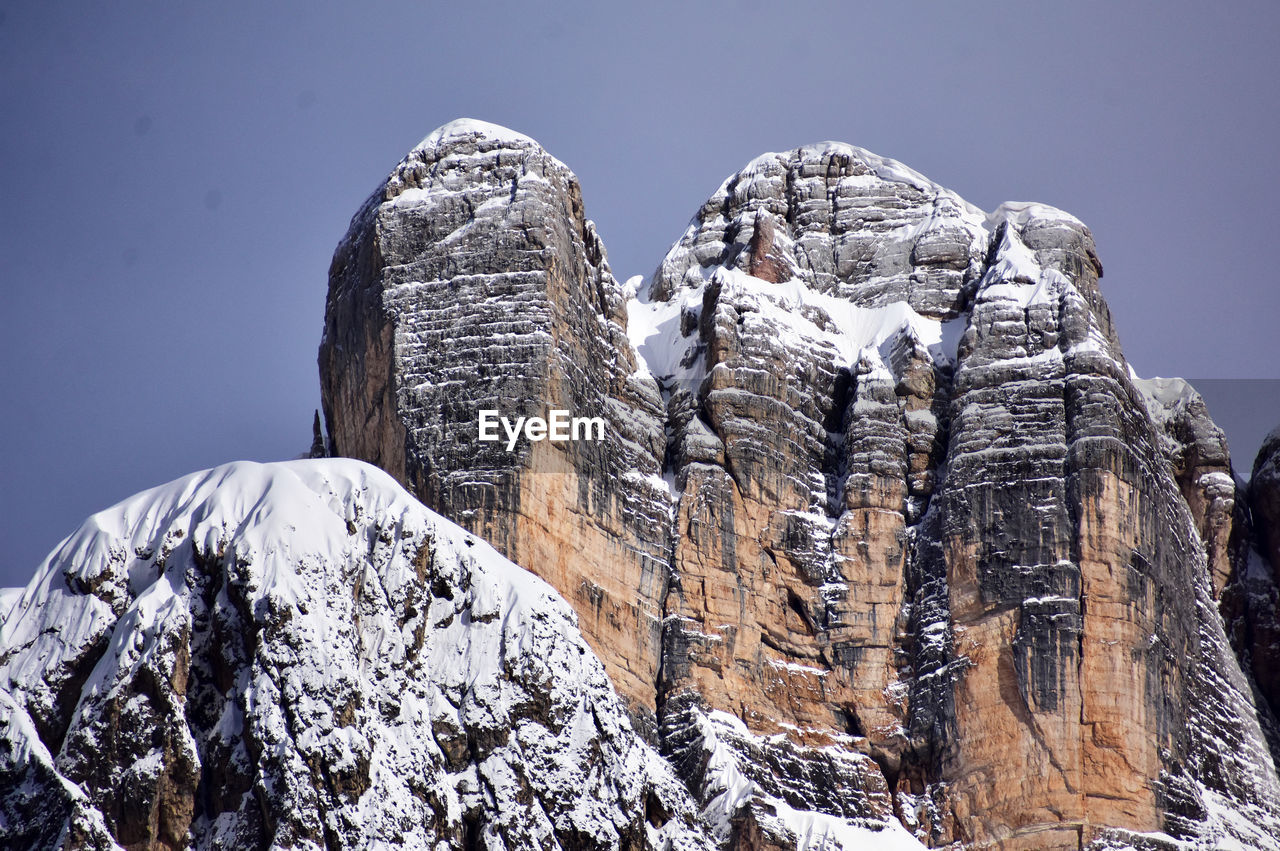 snow, mountain, cold temperature, winter, mountain range, sky, nature, rock, scenics - nature, beauty in nature, environment, landscape, travel destinations, summit, no people, travel, ridge, snowcapped mountain, outdoors, tranquility, mountaineering, clear sky, rock formation, frozen, ice, day, extreme terrain, land, non-urban scene, tourism, tranquil scene, mountain peak, low angle view, adventure