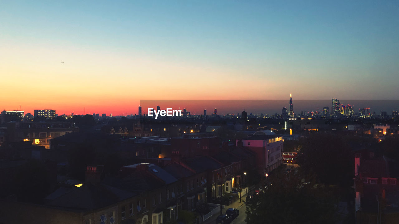 High angle view of illuminated buildings against sky during sunset