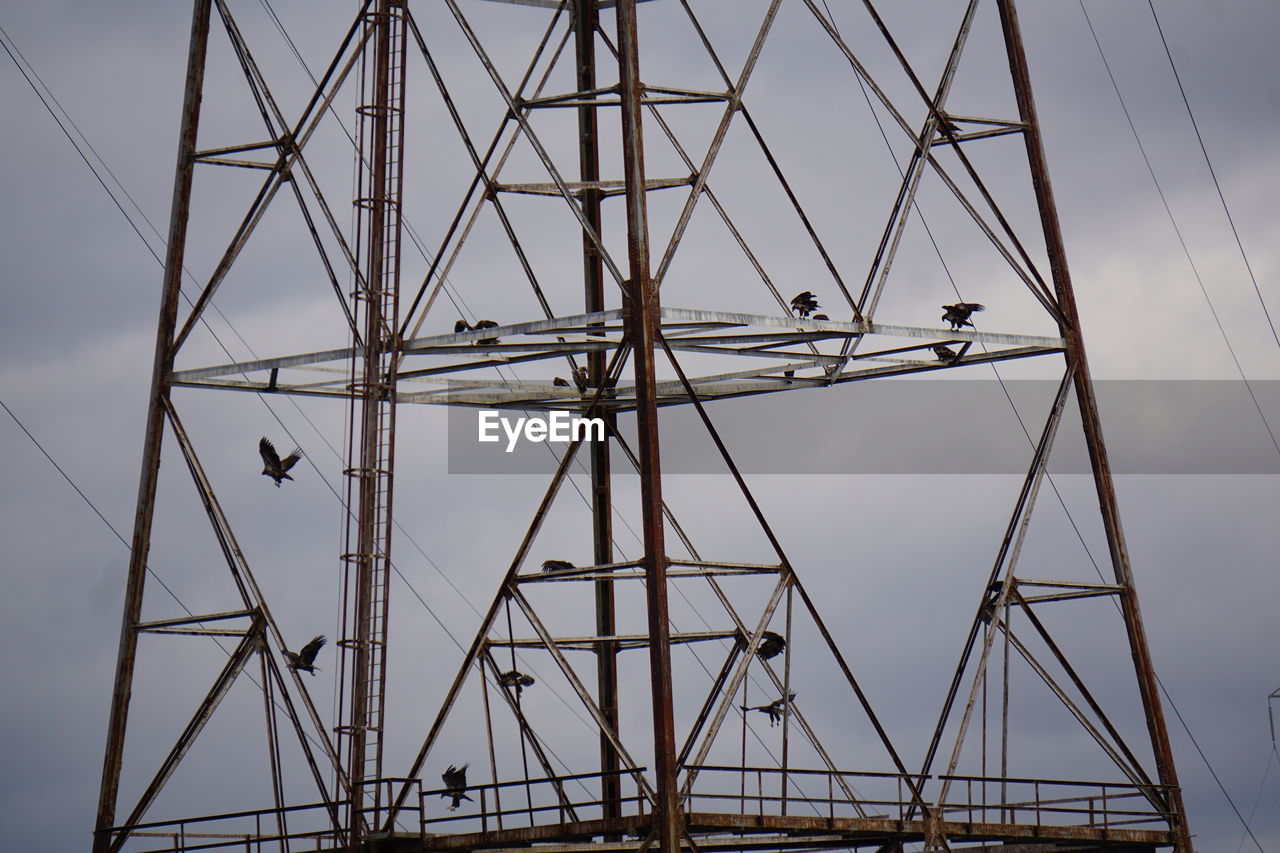 Low angle view of electricity pylon against sky