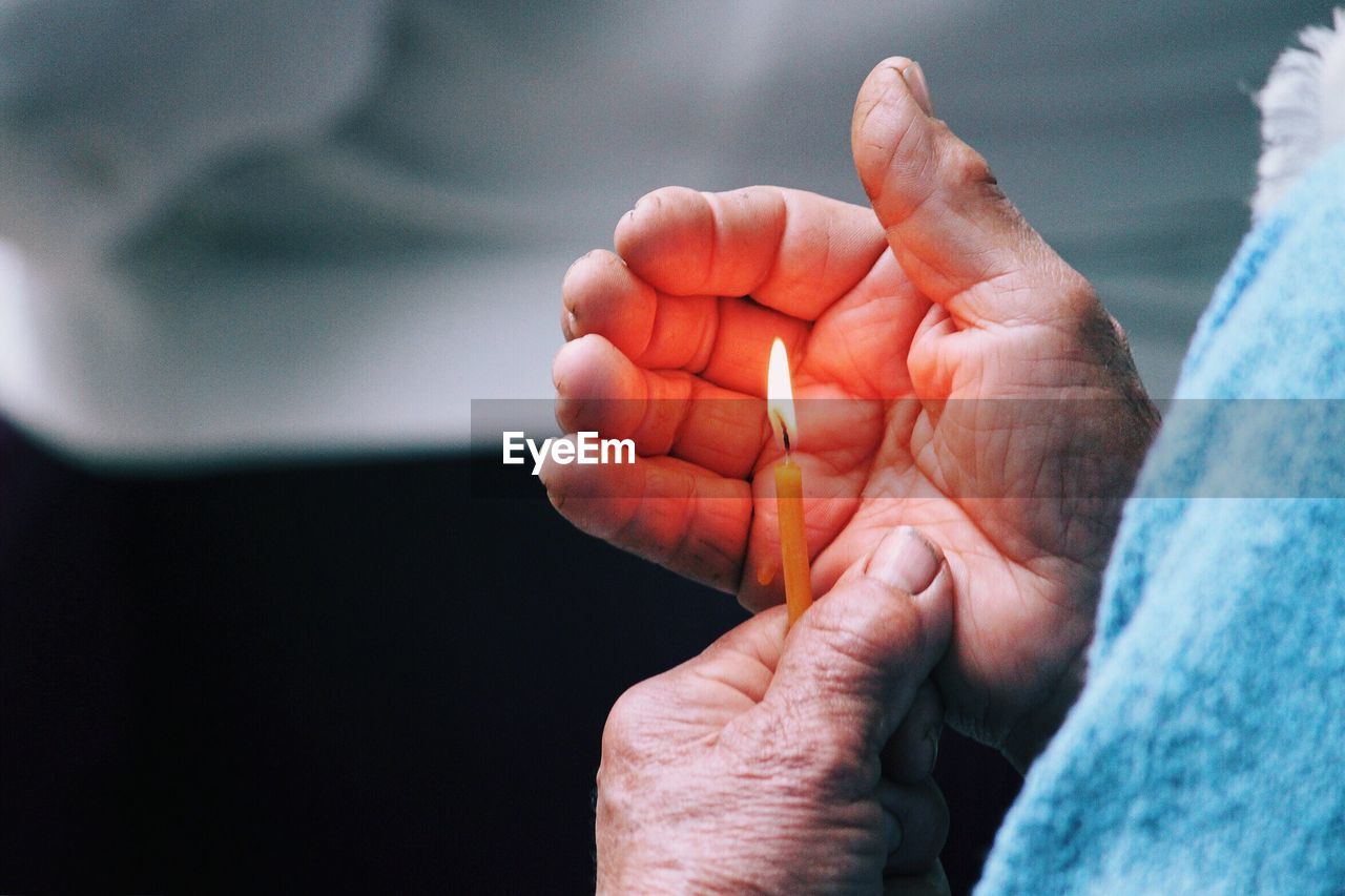 Close-up of hand holding candle