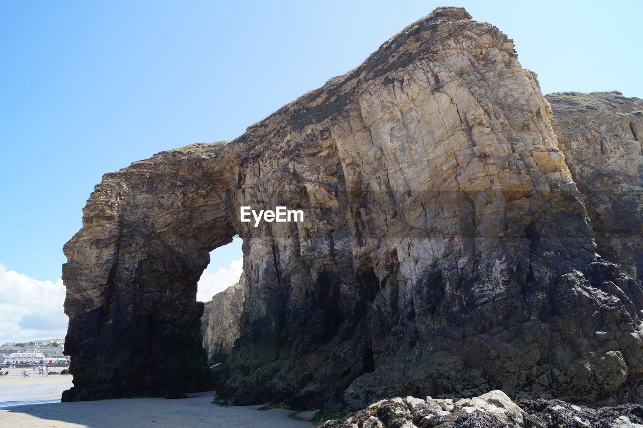 Rock formation in sea against clear sky