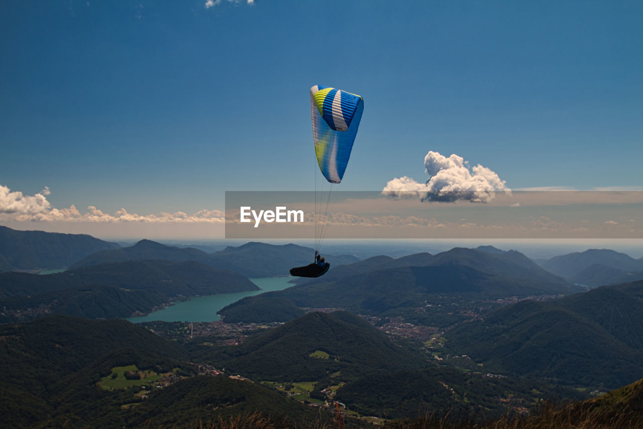 Scenic view of mountains against sky with paragliding