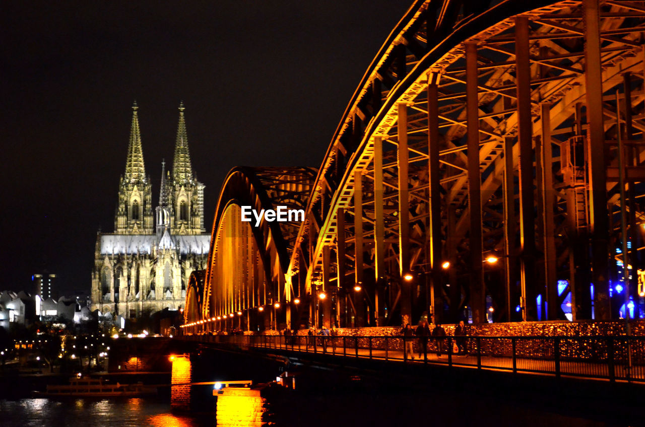 Illuminated hohenzollern bridge over rhine river with cologne cathedral