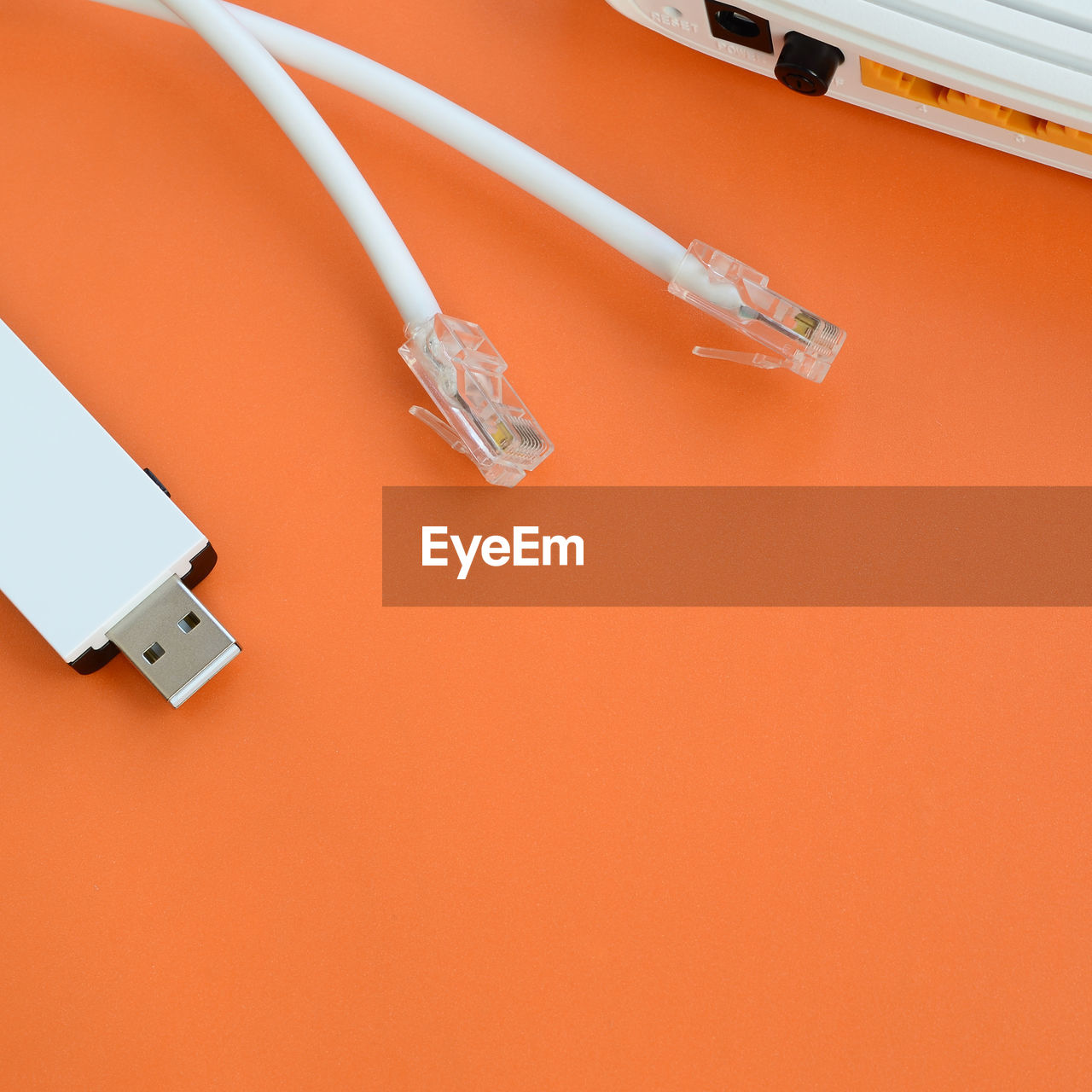 High angle view of router with cables on orange background