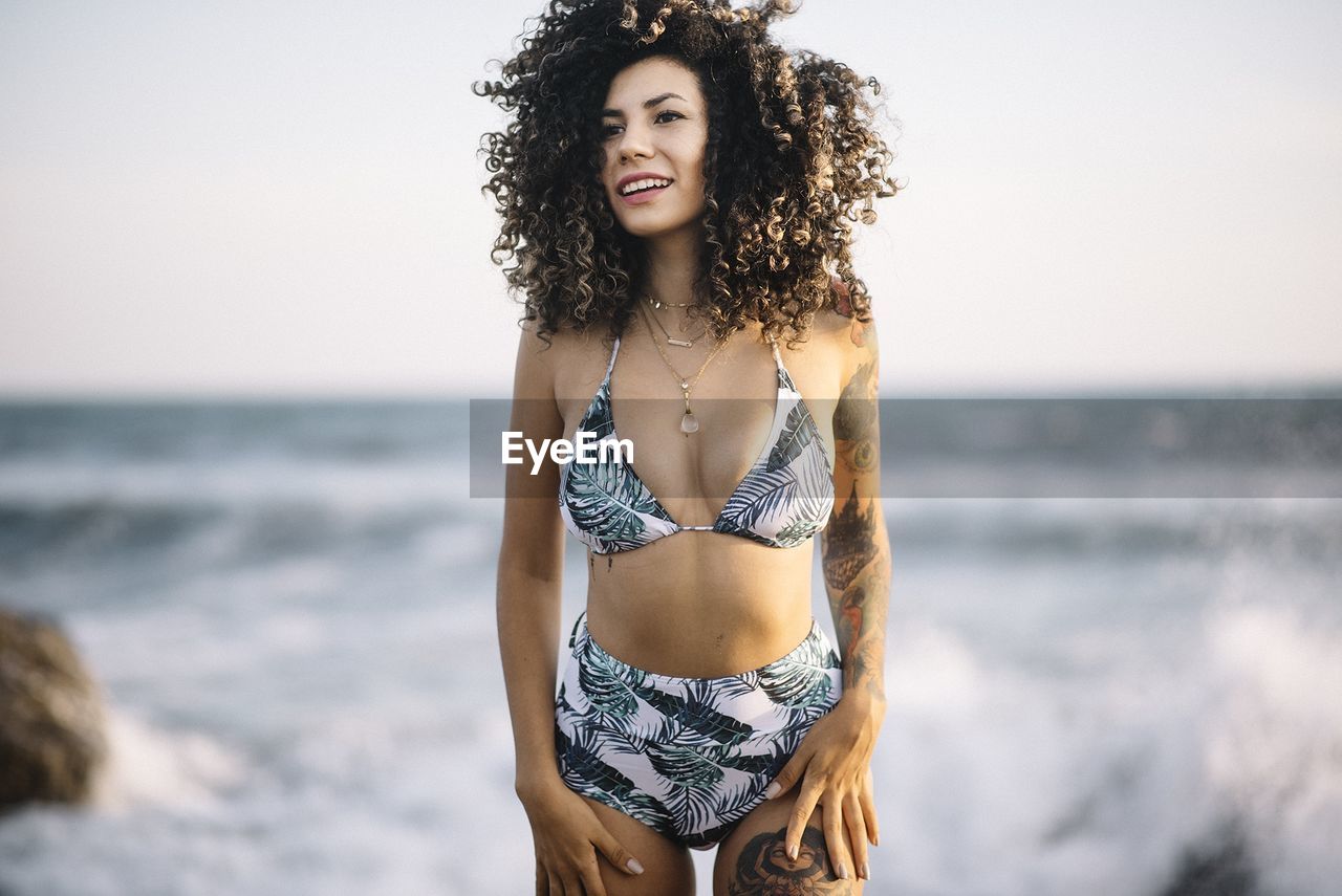 Woman in bikini standing at beach