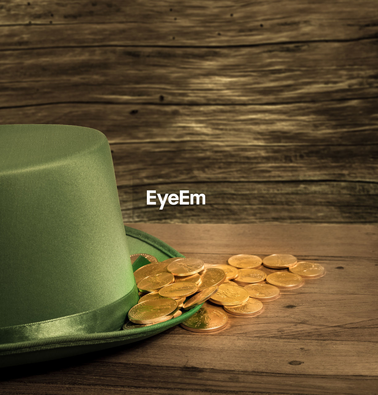 Close-up of hat and coins on wooden table