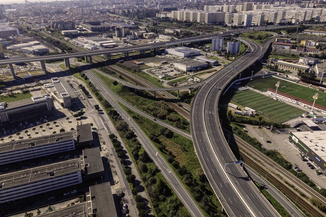 HIGH ANGLE VIEW OF HIGHWAY AMIDST CITY