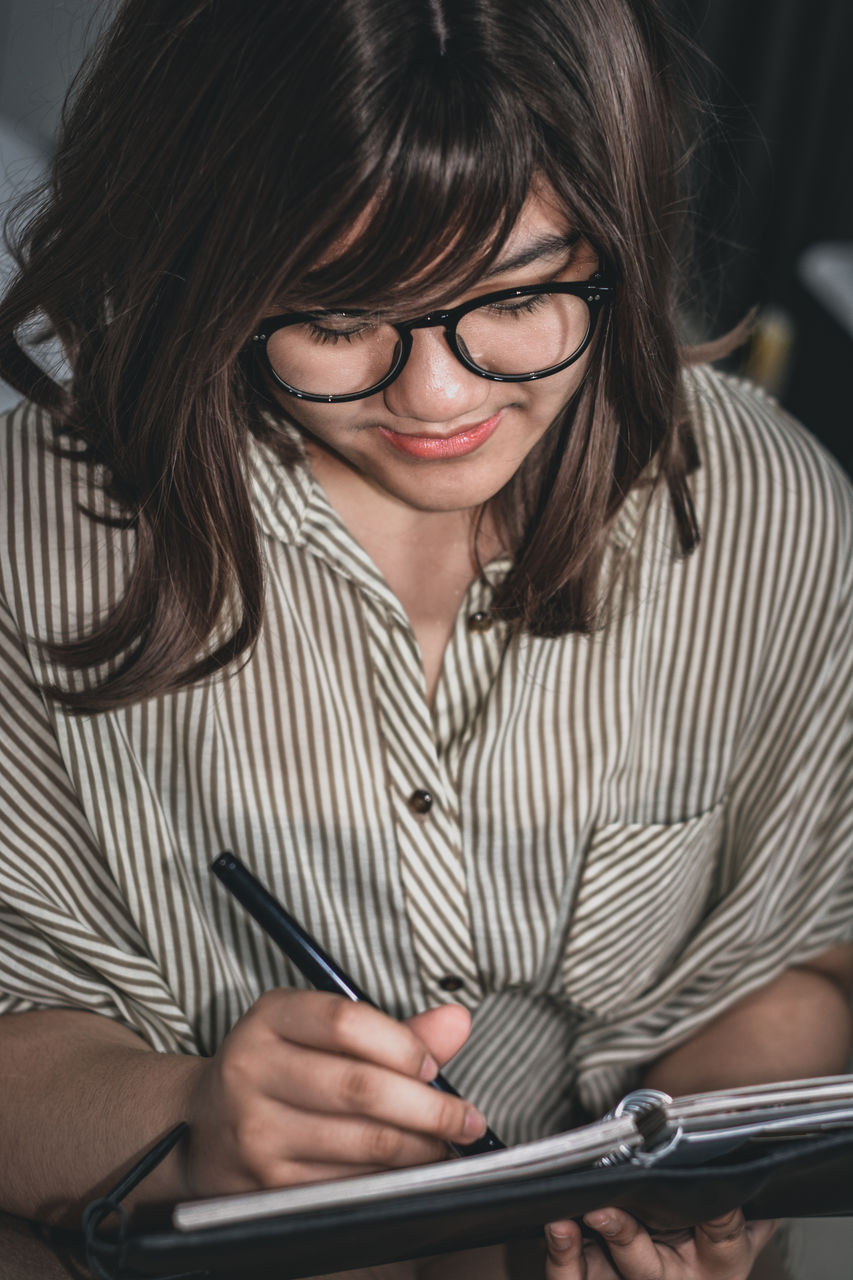 Portrait of a young girl reading a book with leather cover