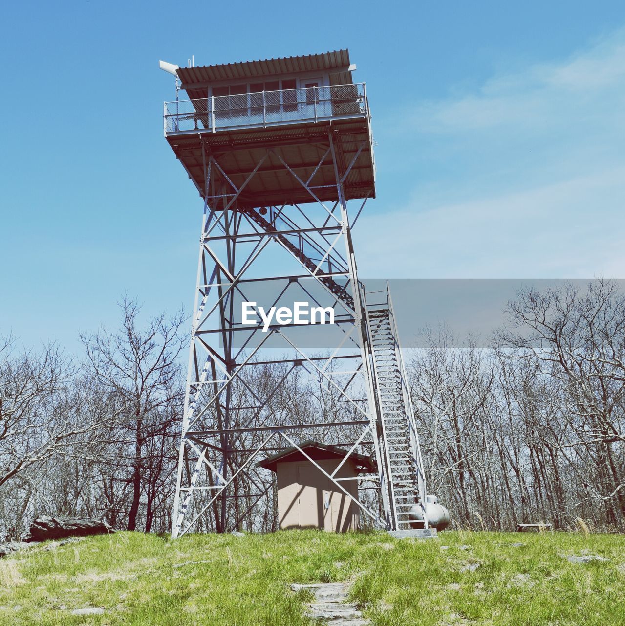 Low angle view of lookout tower on field against sky