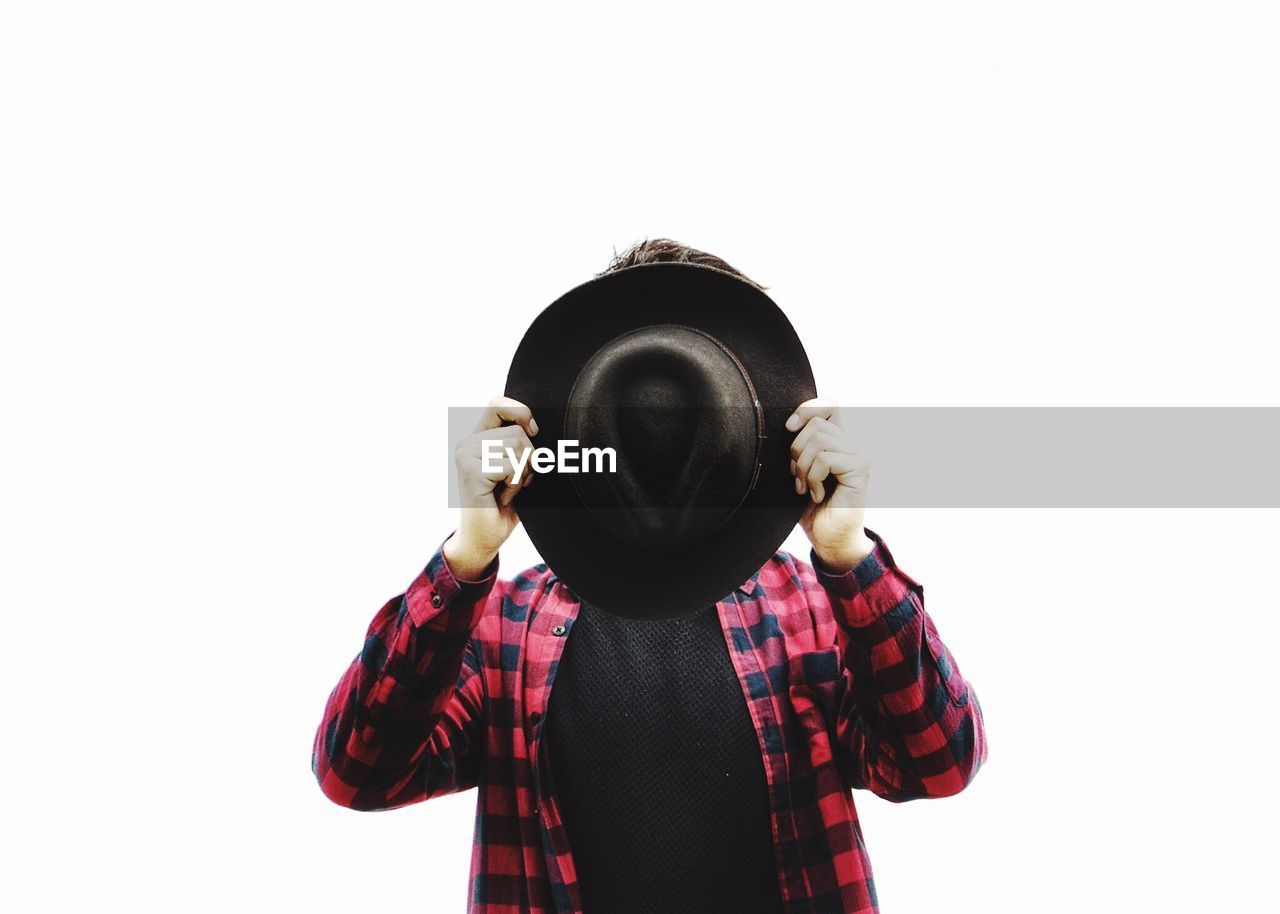 MIDSECTION OF MAN WEARING HAT AGAINST WHITE BACKGROUND