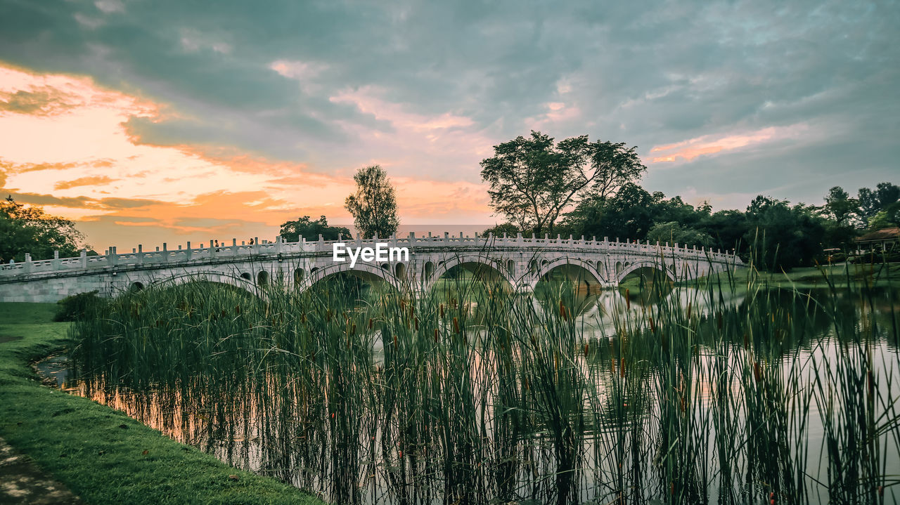 Bridge over river against sky during sunrise