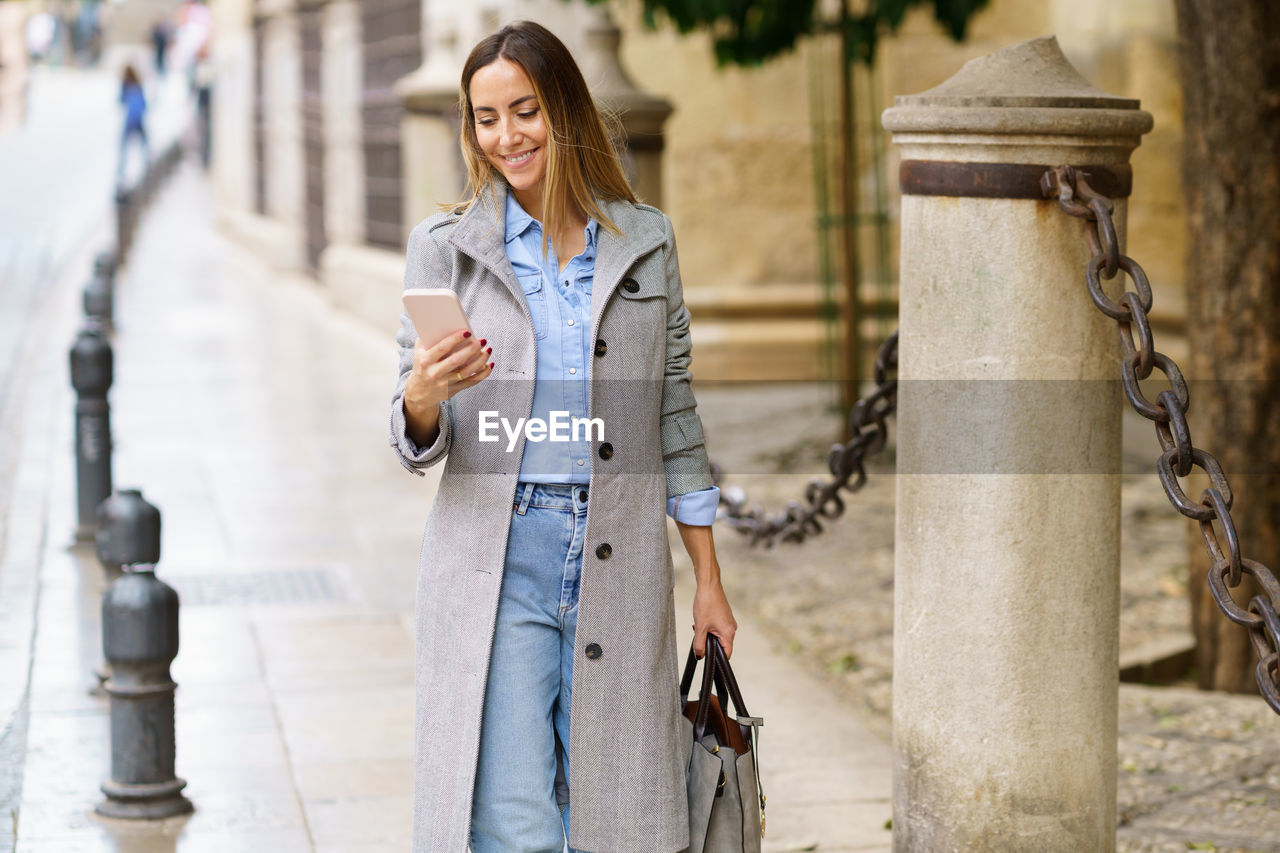 portrait of young woman standing in city