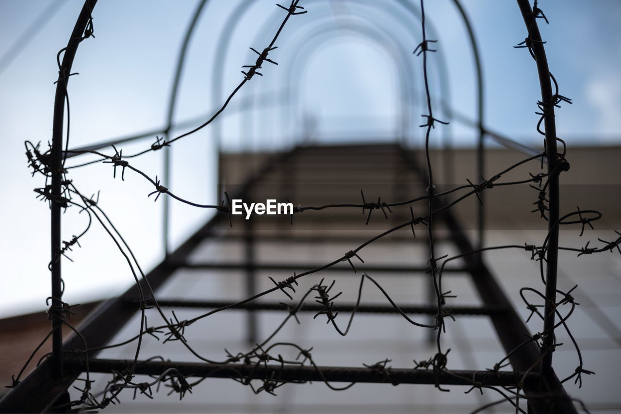 CLOSE-UP OF FENCE AGAINST SKY