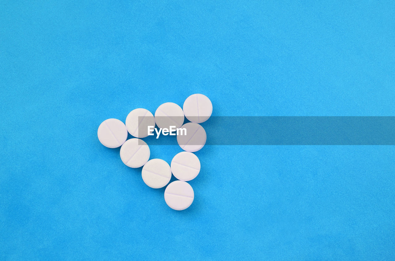 HIGH ANGLE VIEW OF BLUE COLORED PENCILS ON TABLE AGAINST WHITE BACKGROUND