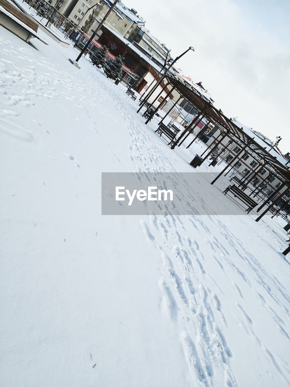 SNOW COVERED LAND BY FIELD AGAINST SKY