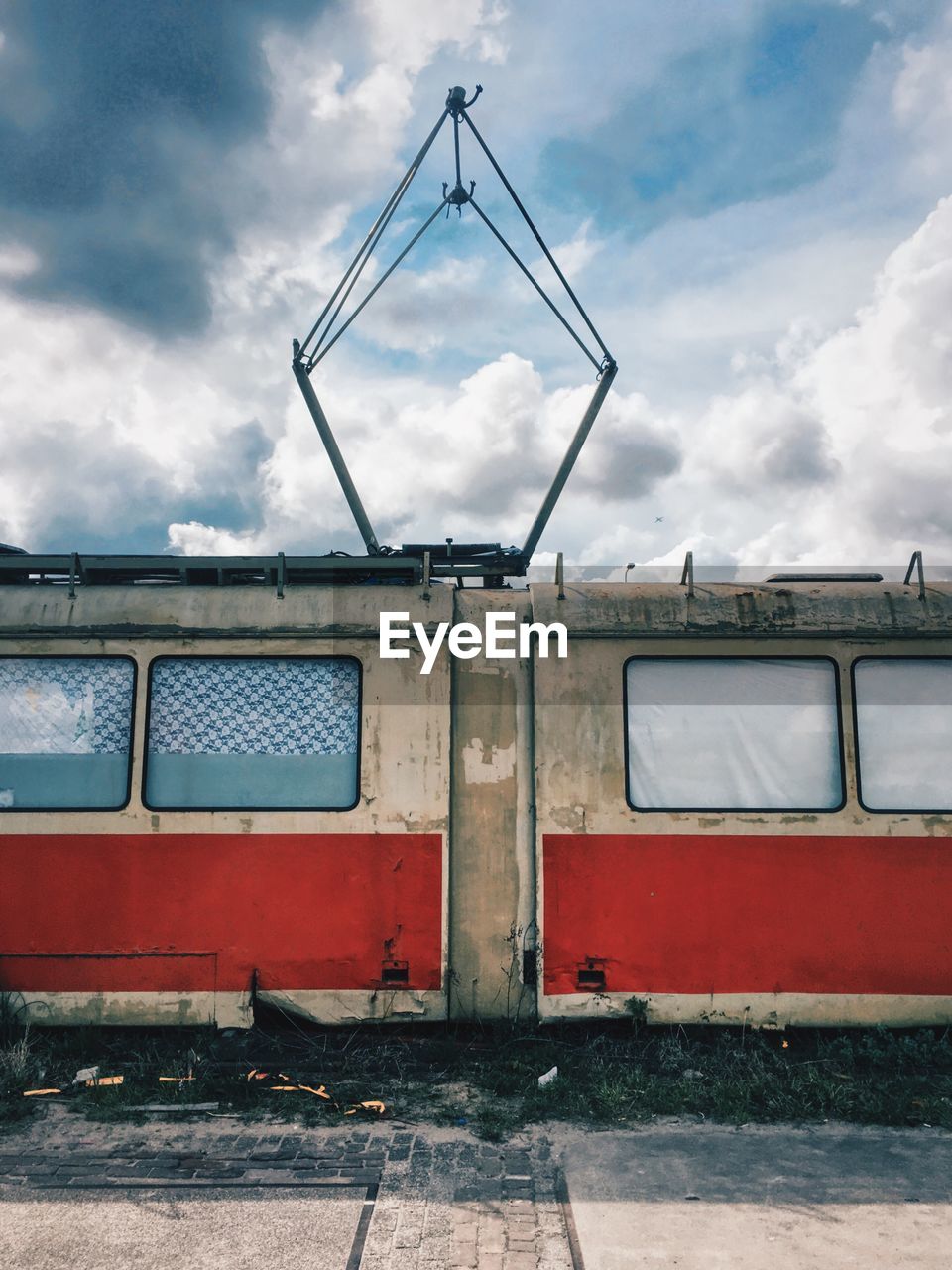 Abandoned tram against cloudy sky