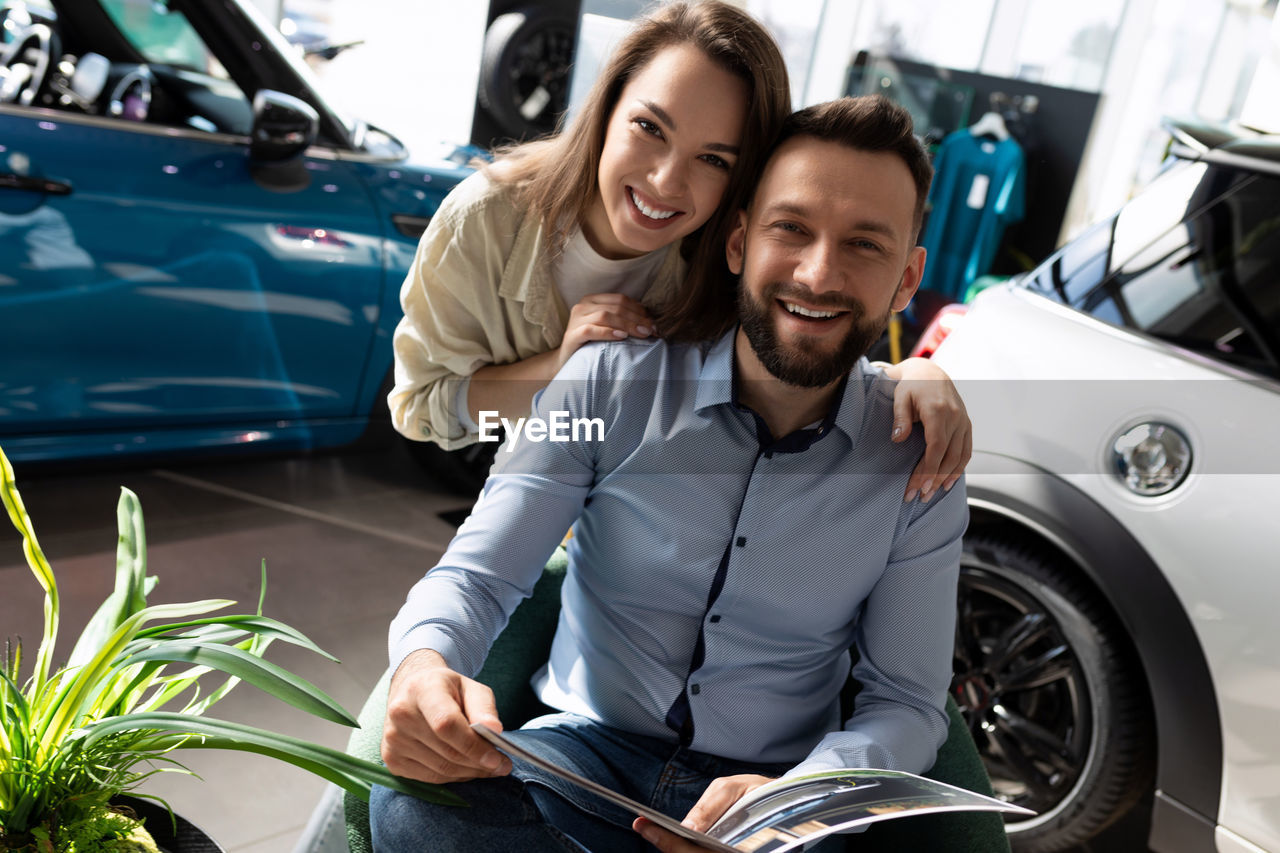 Portrait of happy friends sitting in car