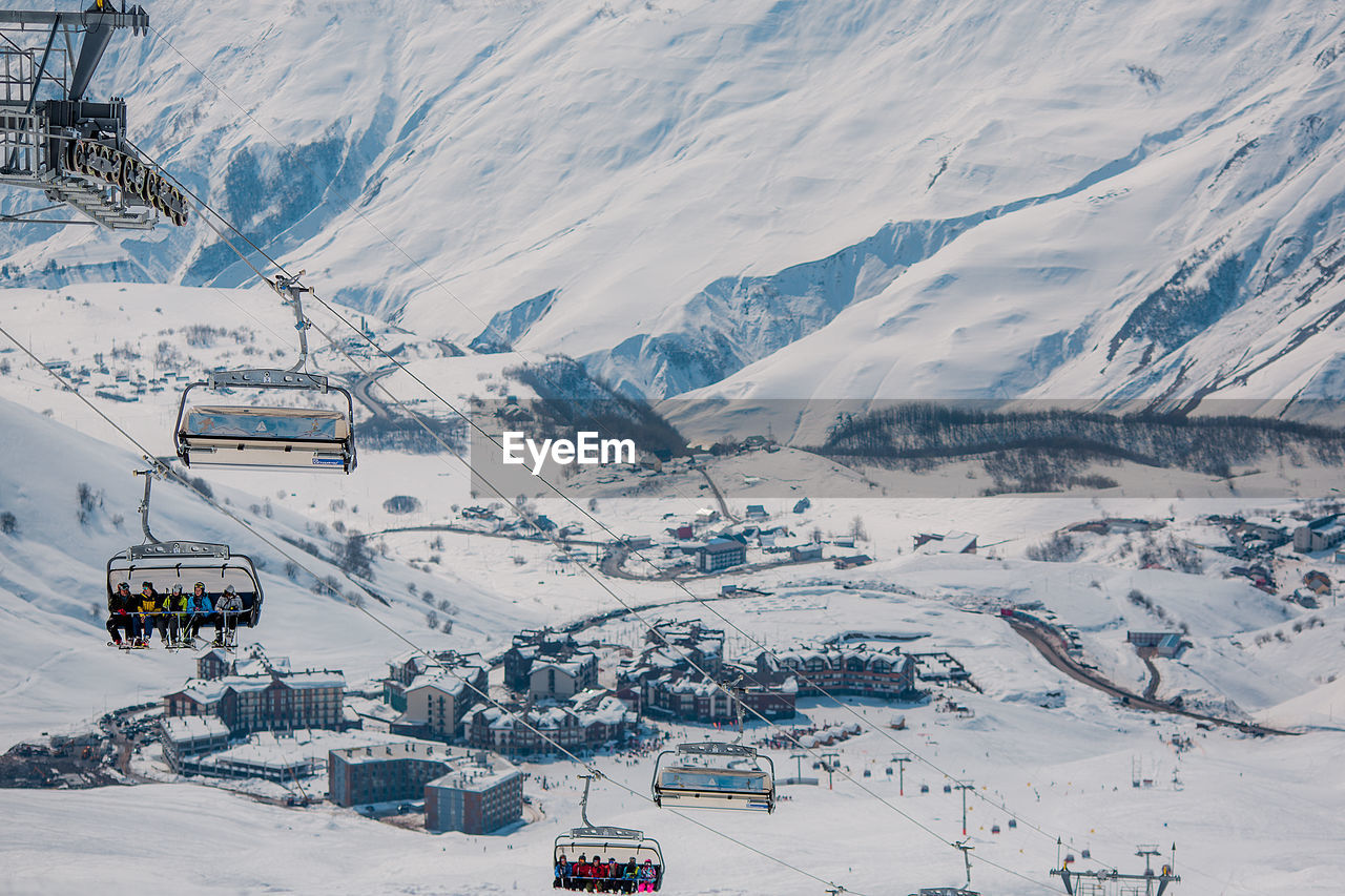 AERIAL VIEW OF PEOPLE SKIING ON SNOWCAPPED LANDSCAPE