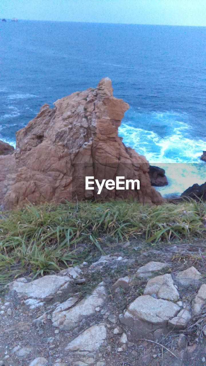 ROCK IN SEA AGAINST SKY