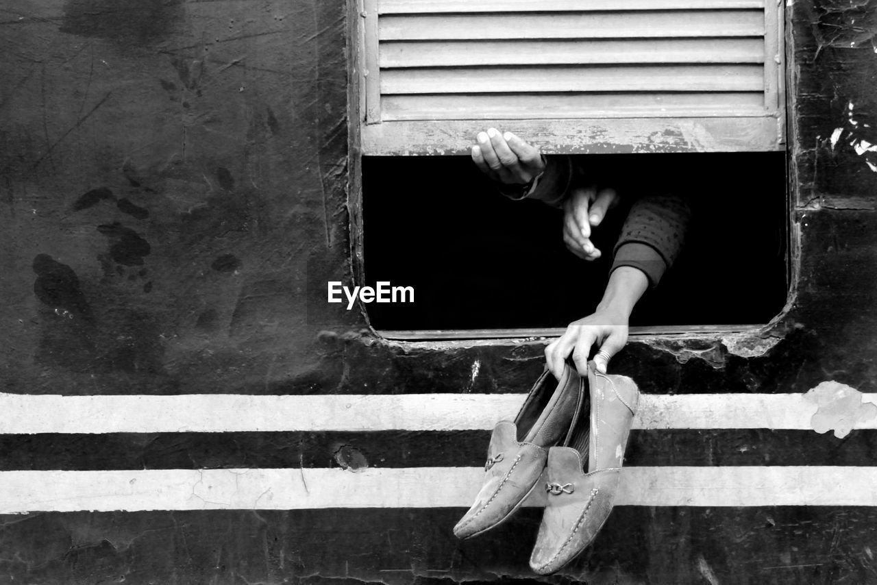 MIDSECTION OF MAN WITH UMBRELLA ON WOOD WINDOW