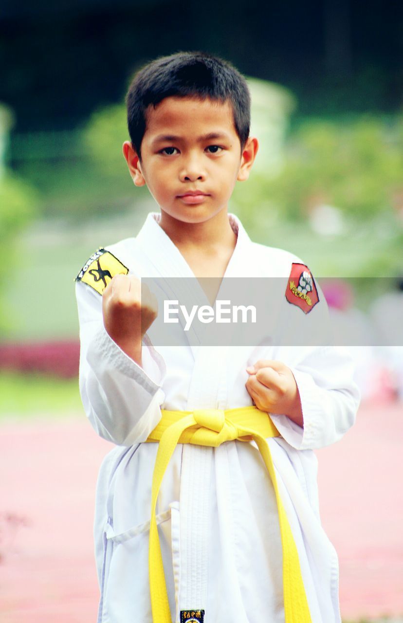 Portrait of boy practicing karate outdoors