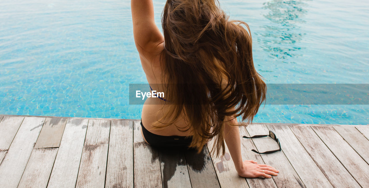 HIGH ANGLE VIEW OF WOMAN WITH ARMS RAISED