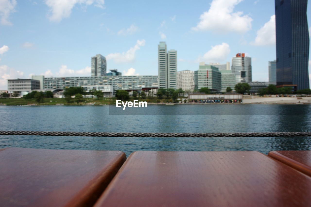 BUILDINGS BY SWIMMING POOL AGAINST SKY