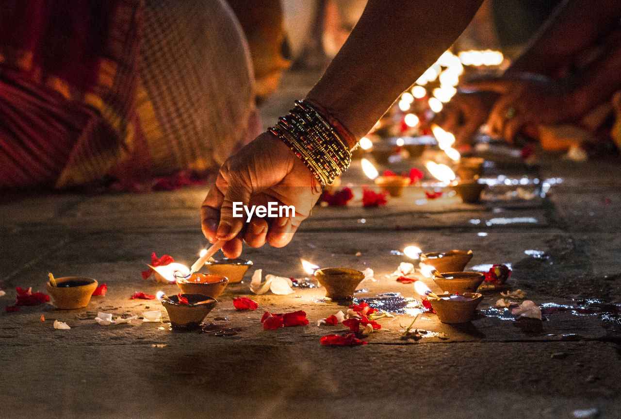 Close-up of hand holding illuminated candles