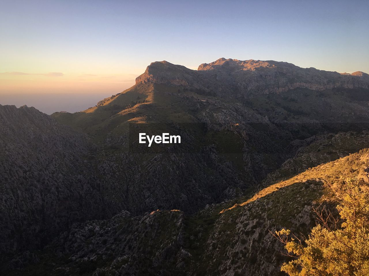 Scenic view of mountains against clear sky during sunset