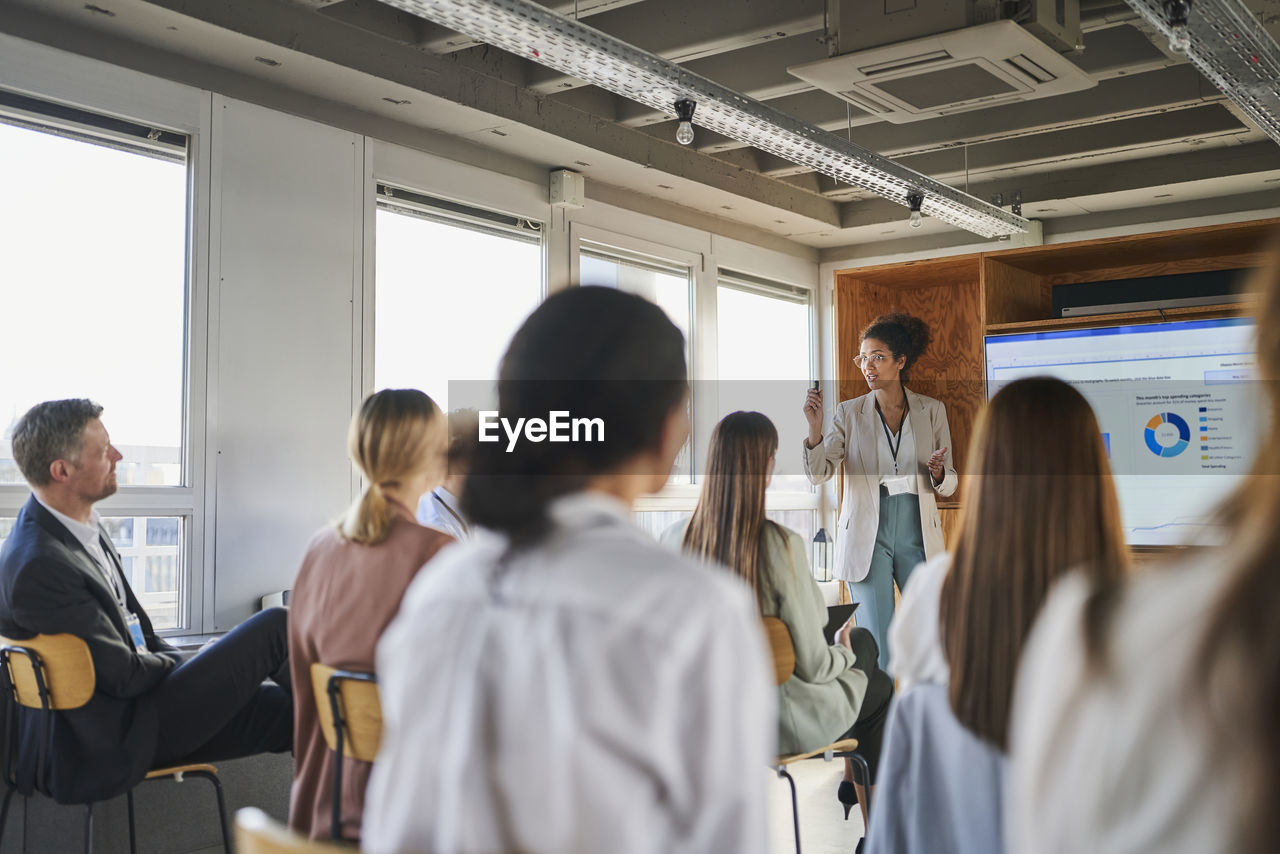 Businesswoman explaining business plan to colleagues in educational event