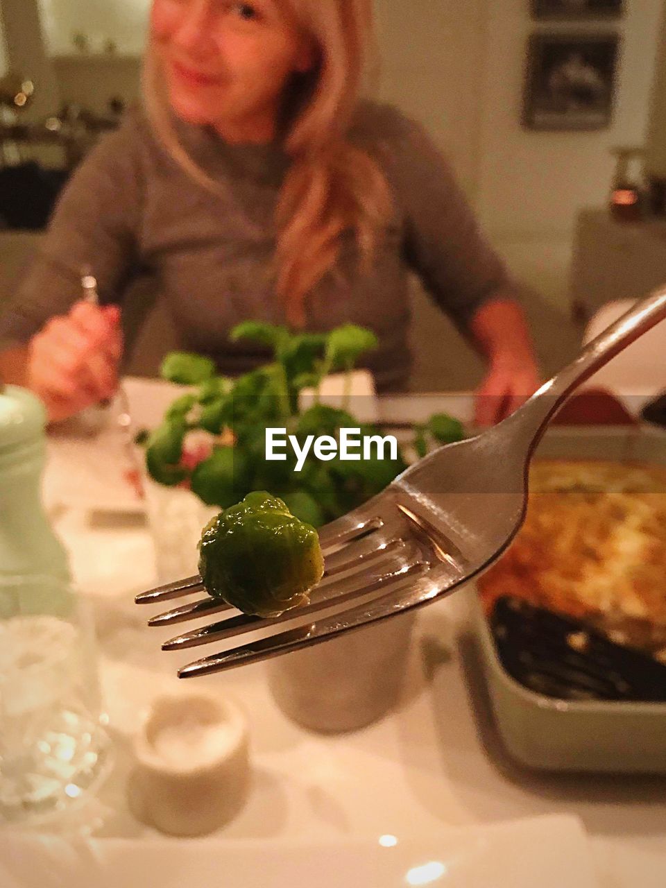 MIDSECTION OF WOMAN EATING FOOD IN RESTAURANT