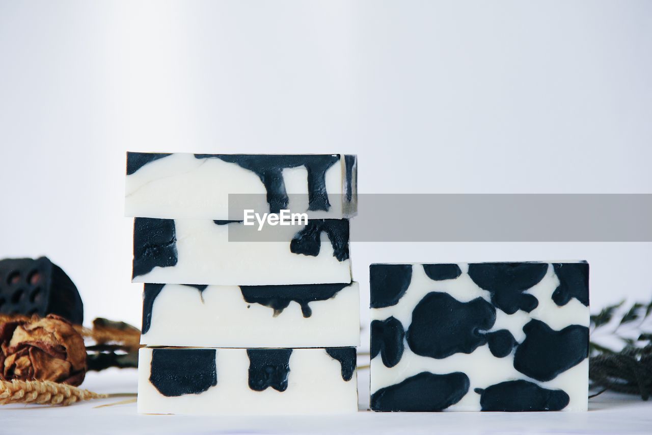 Close-up of soaps stacked against white background