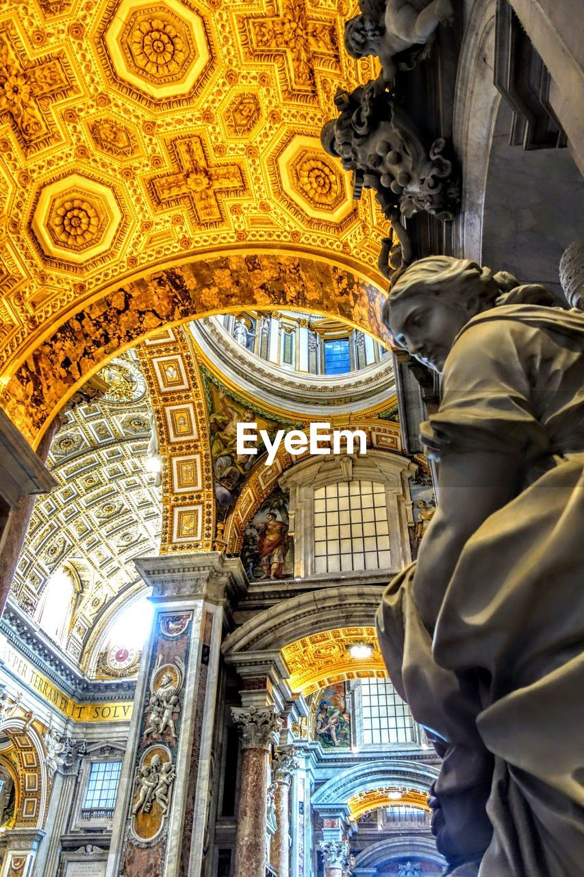 LOW ANGLE VIEW OF ILLUMINATED STATUE IN TEMPLE