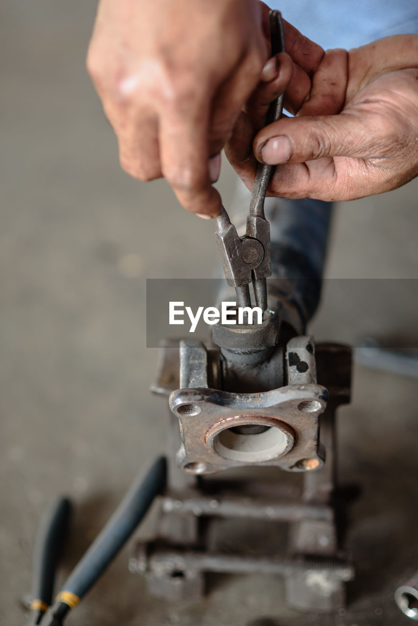 Cropped image of man repairing machine part