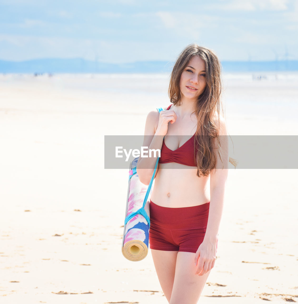 YOUNG WOMAN WEARING SUNGLASSES AT BEACH