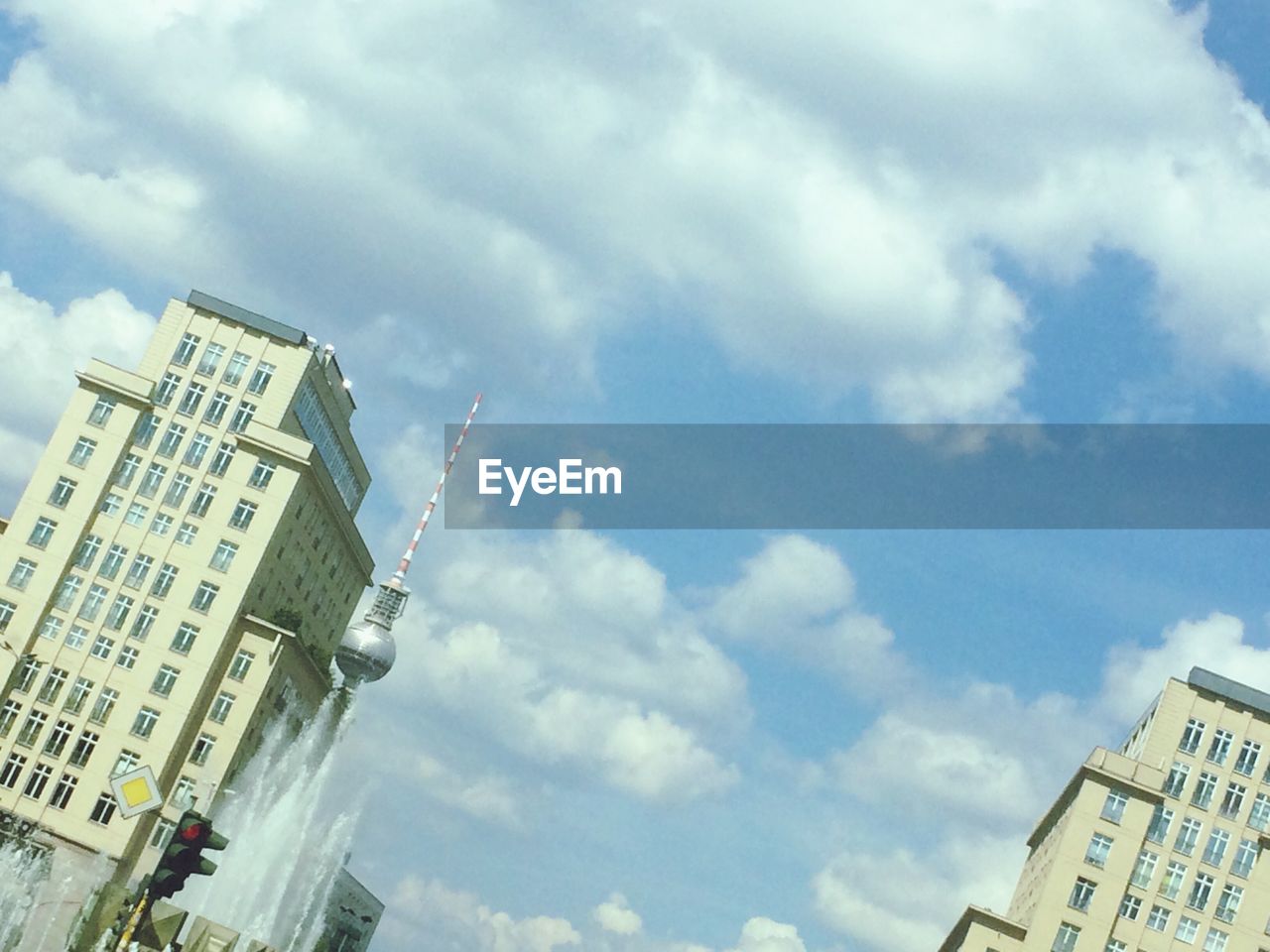 LOW ANGLE VIEW OF MODERN BUILDING AGAINST CLOUDY SKY