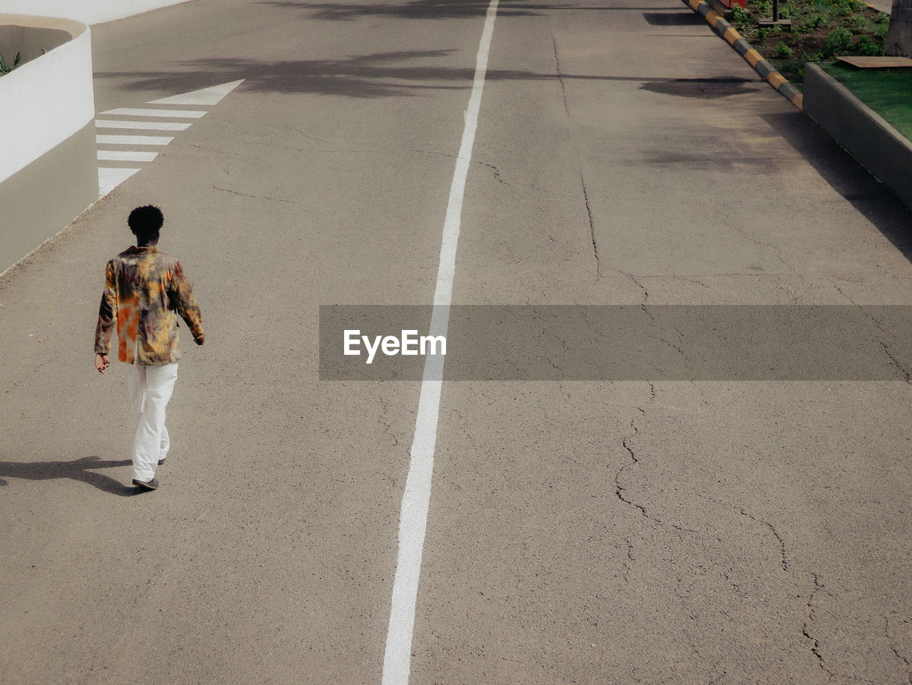 Rear view of man walking on road