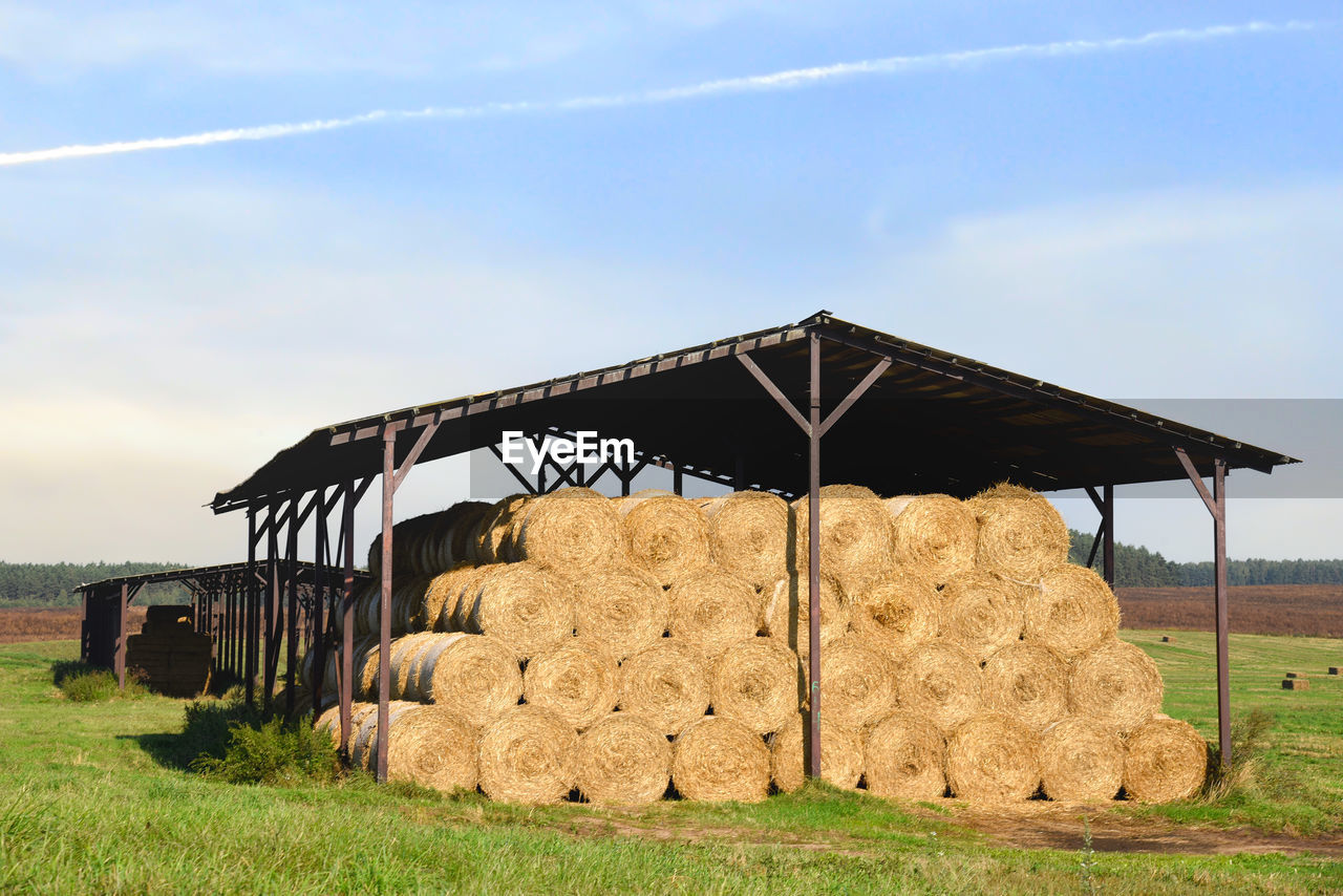 STACK OF HAY BALES ON FIELD