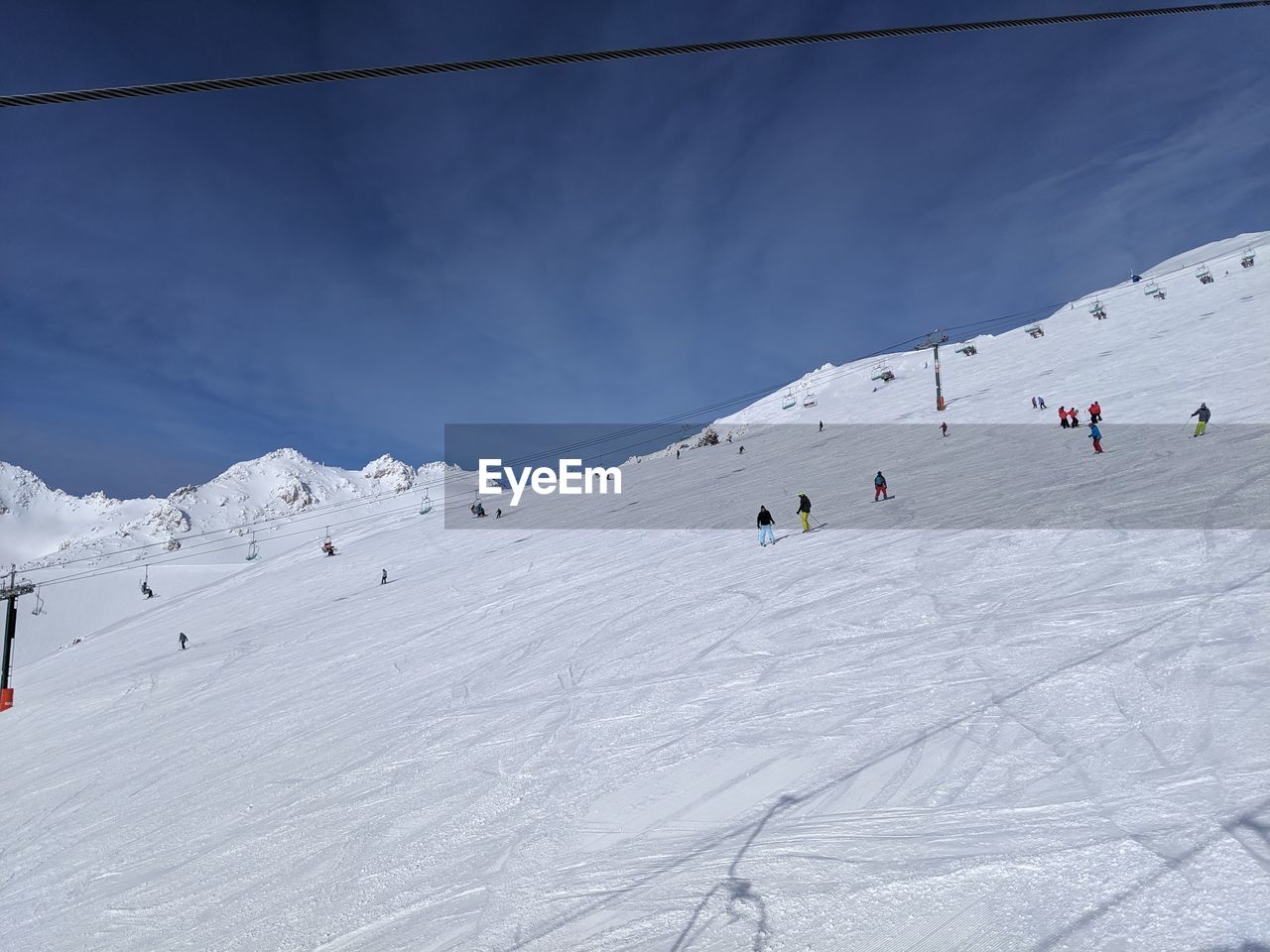 GROUP OF PEOPLE SKIING ON SNOWCAPPED MOUNTAIN