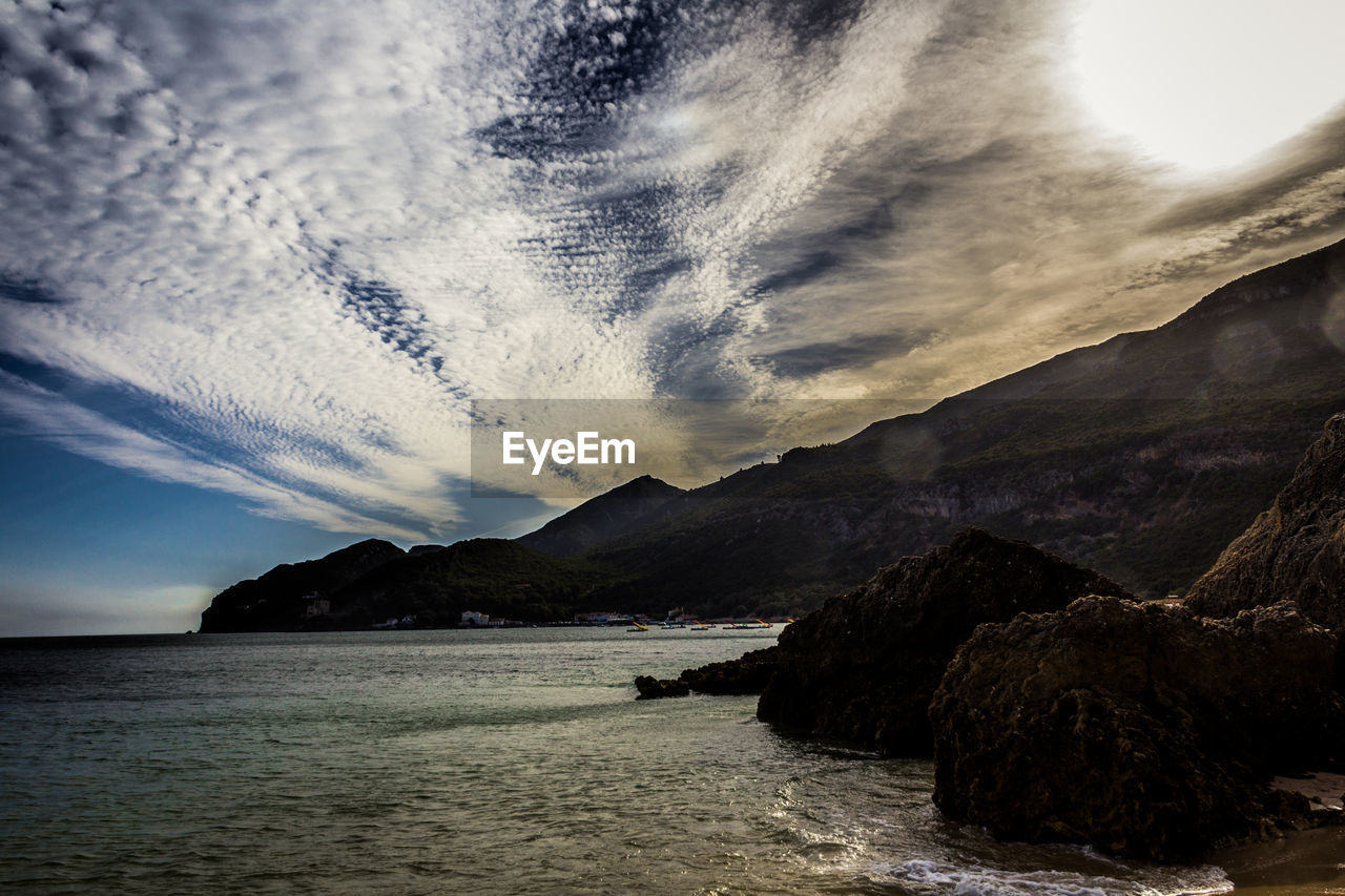 SCENIC VIEW OF SEA BY MOUNTAINS AGAINST SKY