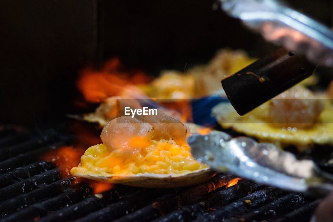 CLOSE-UP OF PREPARING FOOD ON GRILL