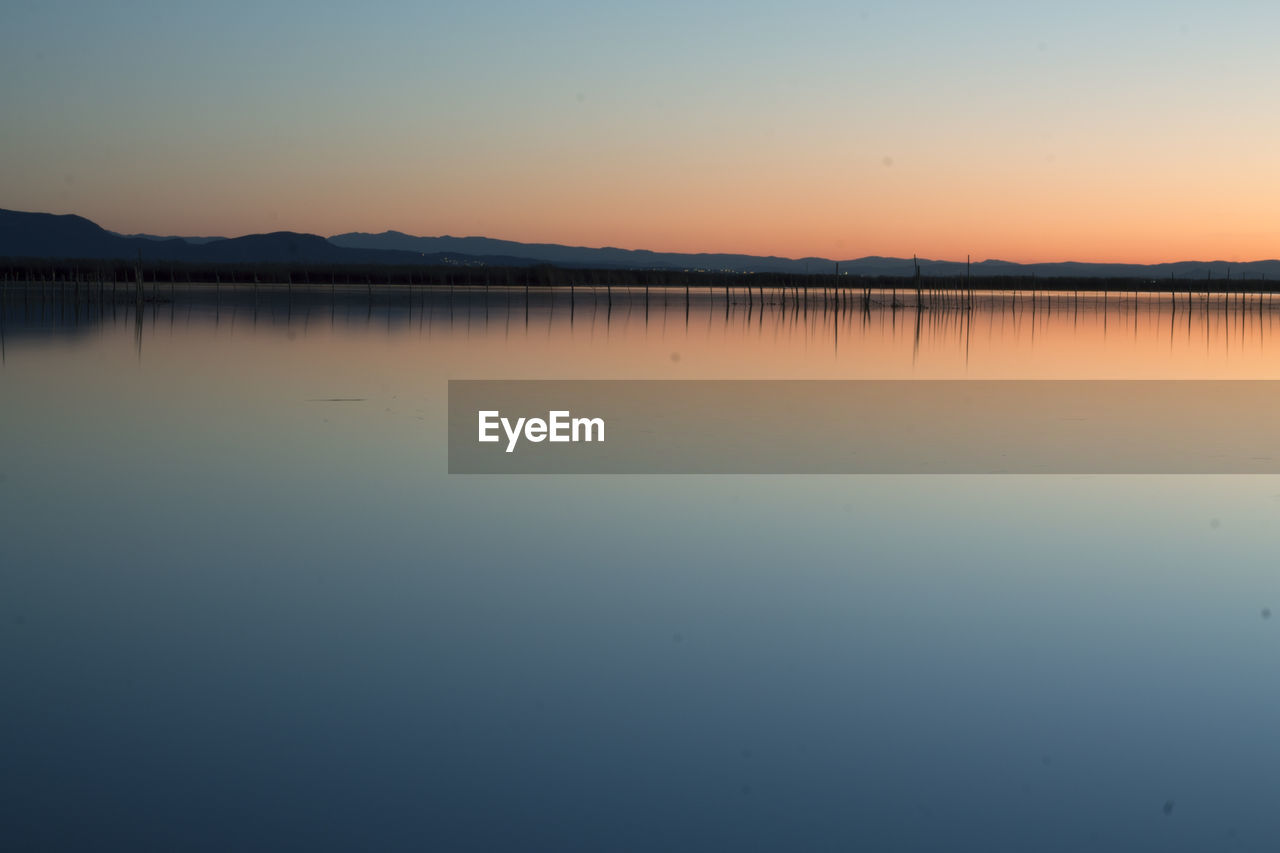 Scenic view of lake against sky during sunset