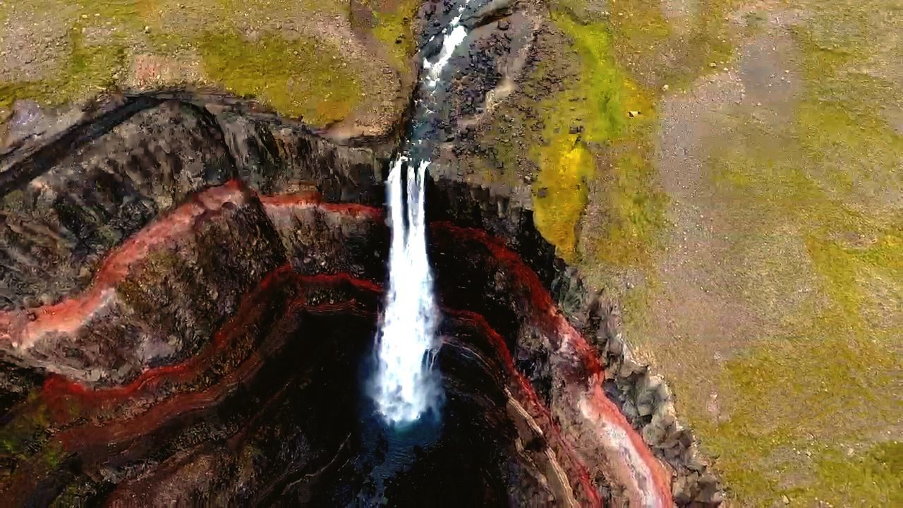 HIGH ANGLE VIEW OF WATERFALL AMIDST RIVER