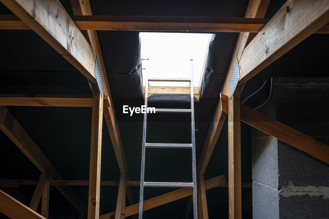 An open roof hatch in the attic for a chimney sweep, a standing ladder in the window.